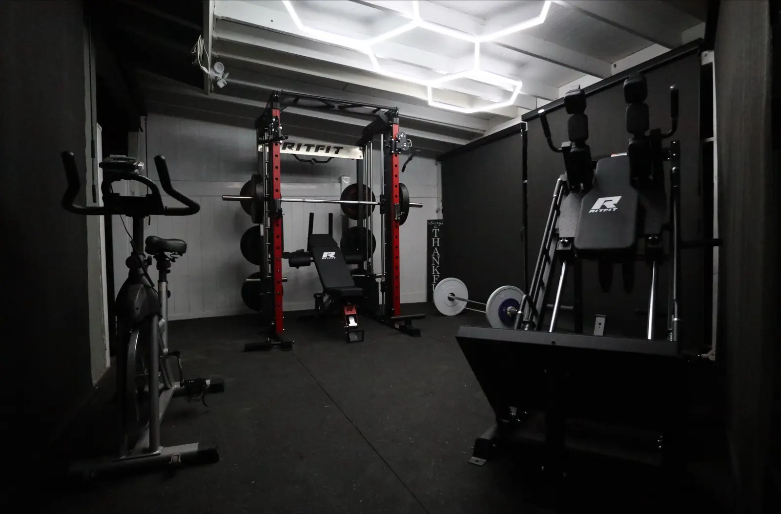 Finished home gym with power rack, bench, and hex lighting